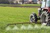 Tractor spraying crop