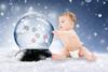 A baby in a disposable nappy with a snowglobe