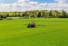 tractor spraying glyphosate pesticides on a field