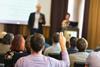 An image showing a man asking a question at a conference