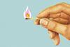 Hand holding matchstick