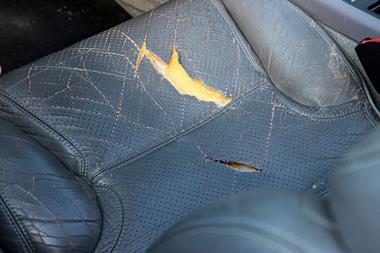 A cracked and torn old car seat made of polyurethane