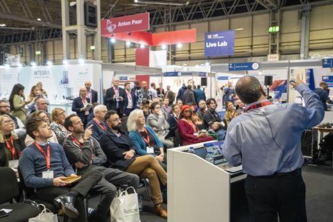 Group of people listening to a speaker give a presentation at a conference