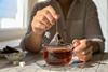 Woman taking teabag out of cup