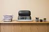 An office desk with a full in tray and an empty chair