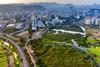 An aerial view of the edge of the city of Mumbai where built up urban area abruptly meets farmland and undeveloped wetland