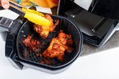 Taking cooked chicked out of an air fryer